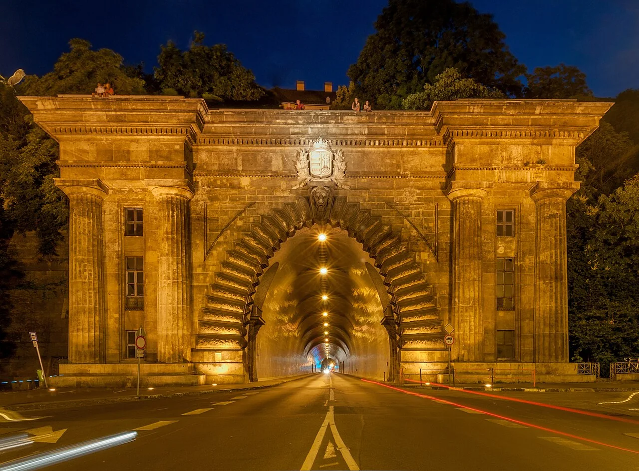 A stone tunnel entrance lit at night in Budapest